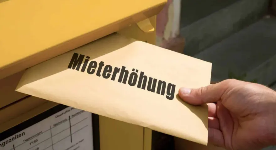 Brief mit "Mieterhöhung" wird in gelben Briefkasten eingeworfen. Wichtige Fristen beachten!