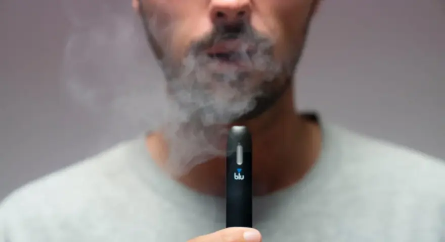 Hombre exhala humo de un vaper blu. Este vaper blu es malo para la salud.