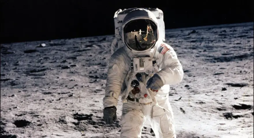 Un astronaute sur la Lune, le 20 juillet 1969. Le reflet dans son casque montre la Terre et d'autres astronautes.