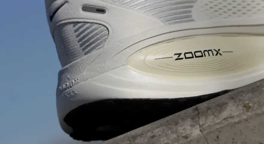 Biały but sportowy z technologią ZoomX. Drop w butach to różnica wysokości między piętą a palcami, kluczowa dla komfortu biegania.