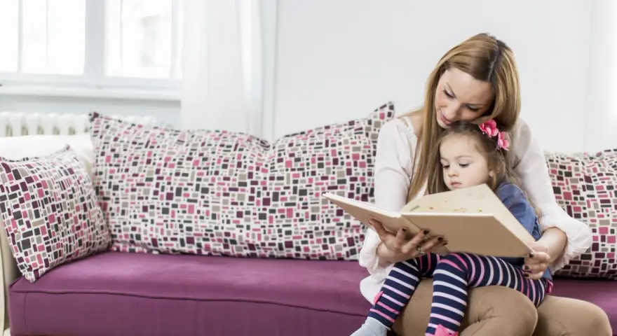 Mama czyta dziecku bajki terapeutyczne. Różne rodzaje bajek pomagają w rozwoju emocjonalnym.