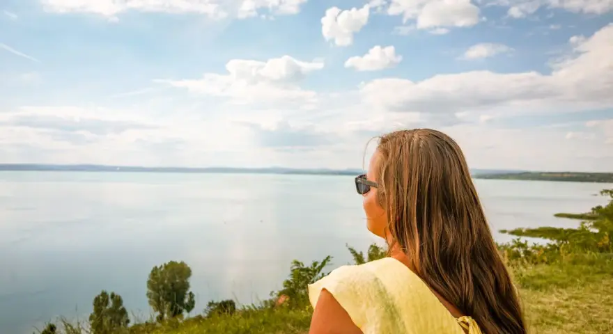 Kobieta w żółtej bluzce podziwia widok na Balaton. Wspaniałe chmury na niebie, idealne miejsce, gdzie nad Balaton.