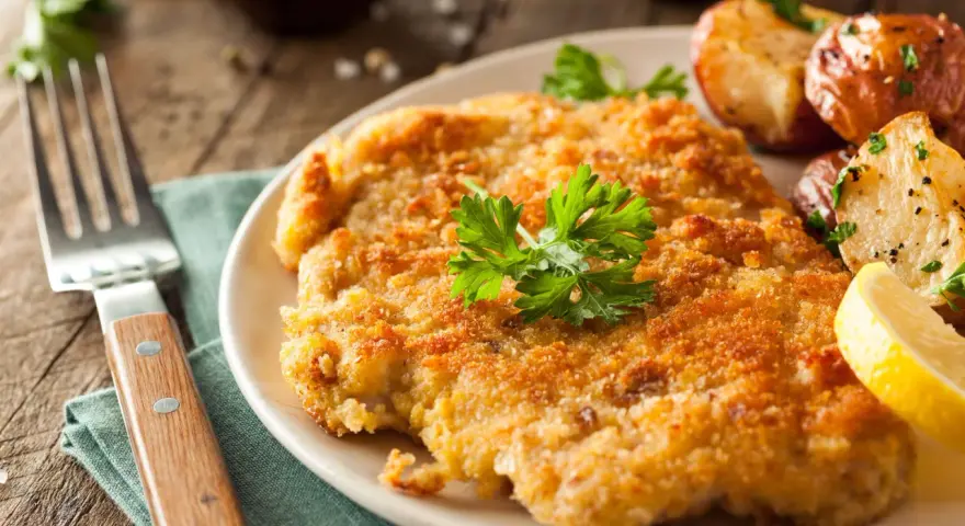 Wiener Schnitzel con patate arrosto e limone: un classico da provare per scoprire cosa mangiare a Vienna.