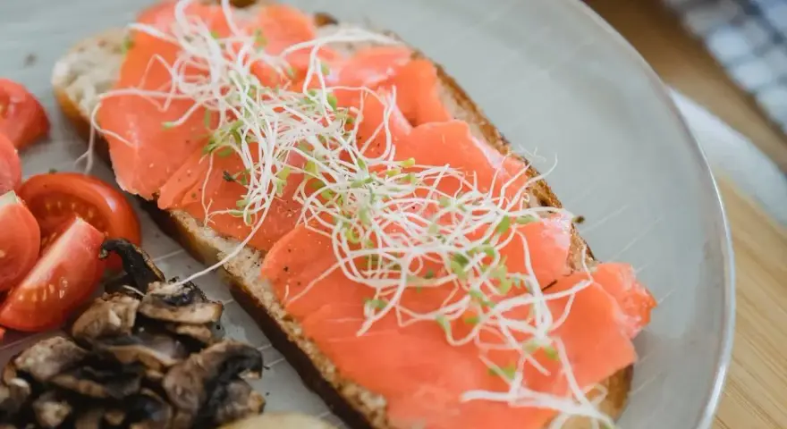 Kanapka z wędzonym łososiem, kiełkami, pomidorkami i pieczarkami. Idealna dla przyszłej mamy dbającej o zdrową dietę.