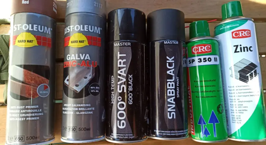Flera sprayburkar med rostskydd och färg, inklusive galv spray för metall.