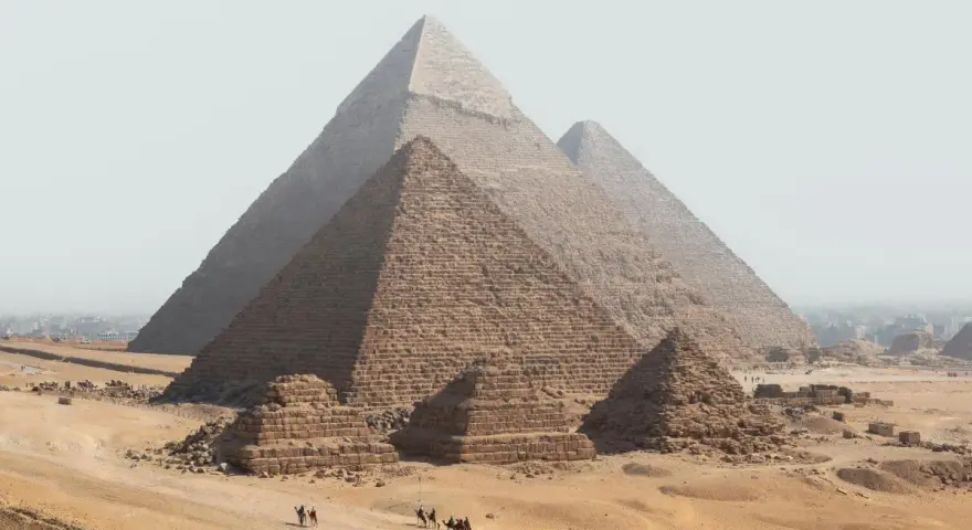 Piramide w Gizie z karawaną wielbłądów na pustyni.