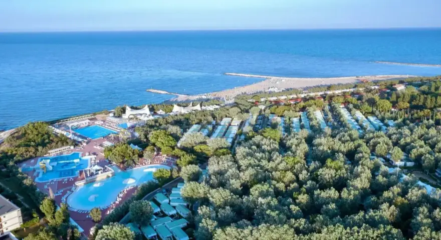 Widok z lotu ptaka na **camping Isamar** z basenami, domkami kempingowymi i plażą nad morzem.
