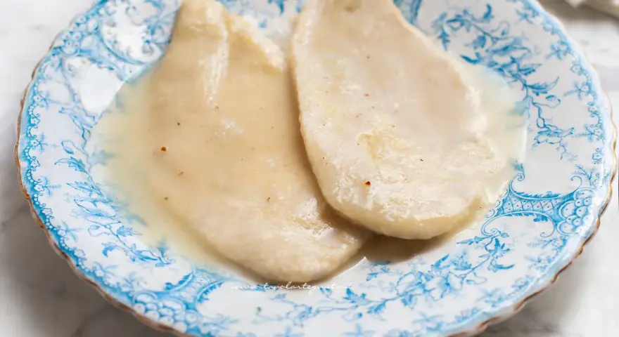 Delicate scaloppine al vino bianco, servite su un piatto decorato con motivi blu.