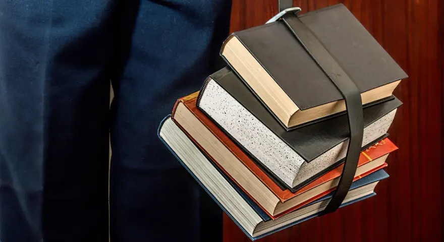 Un fascio di libri legati da una cinghia, un simbolo del percorso per capire come funzionano i CFU e il carico di studio.