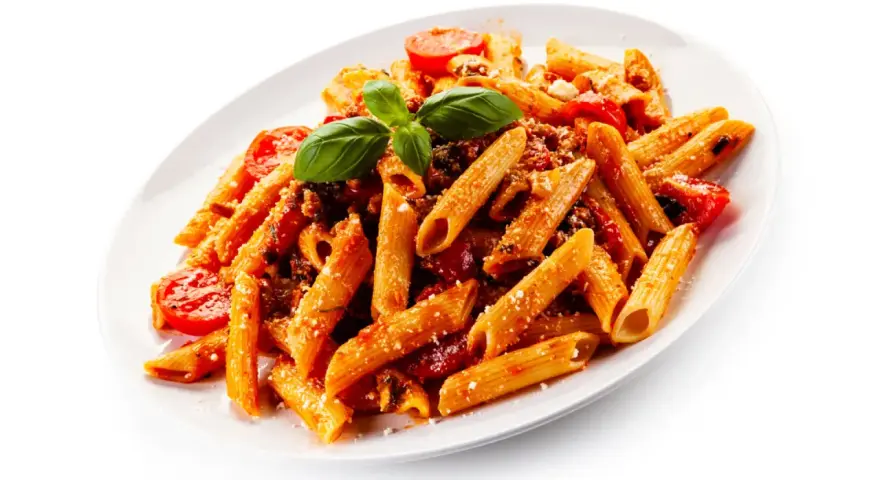 Un plato de macarrones con tomate, carne picada y albahaca fresca. Un clásico italiano listo para disfrutar.