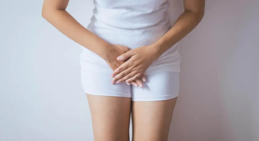 Kobieta w białej bieliźnie, dłonie zasłaniające krocze. Może symbolizować żółte upławy w okresie menopauzy.