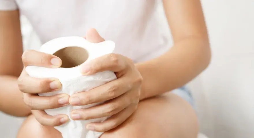 Mani che stringono un rotolo di carta igienica, un rimedio immediato per andare in bagno.