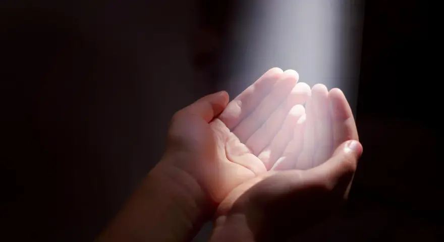 Hände im Licht, die Hoffnung suchen. Ein Symbol für gott und das Leid, das durch Glauben überwunden werden kann.