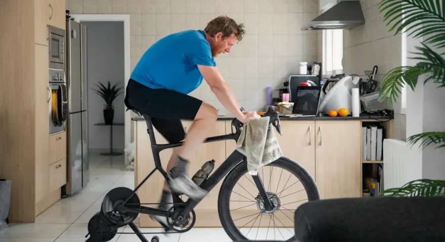 Man doing indoor cycling for beginners in his kitchen.