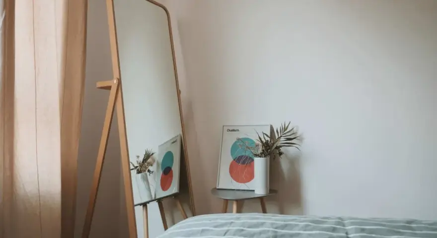Lustro odbija plakat z kołami i wazon z suszonymi kwiatami. To inspiracja do stworzenia własnej konmari listy porządków.