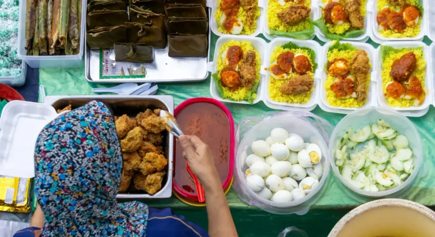 Stoisko z pysznym, halal jedzeniem: ryż z kurczakiem, jajka na twardo, ogórki i sos.
