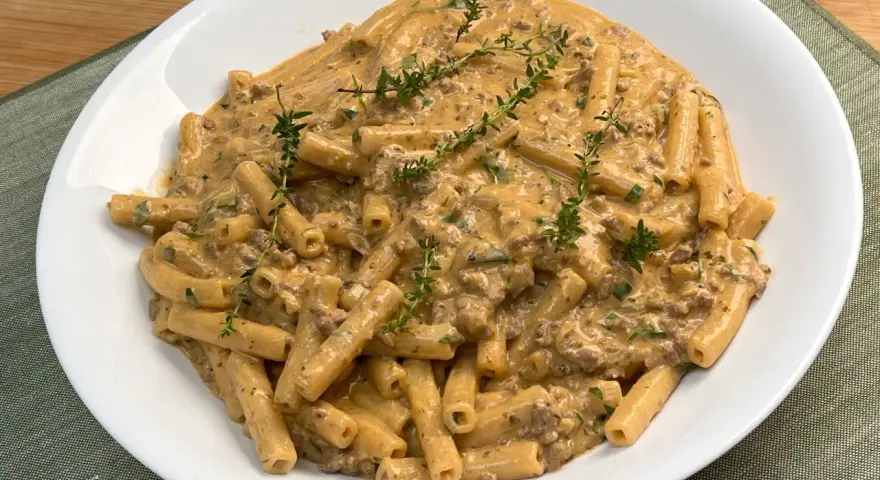 Piatto di pasta alla montecarlo con ragù cremoso e timo fresco.