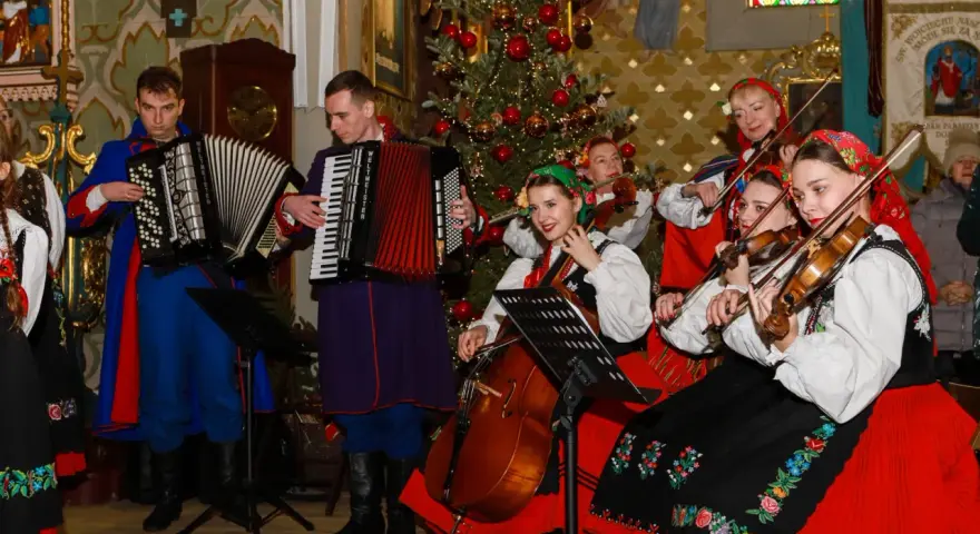 Zespół w strojach ludowych grający wszystkie kolędy polskie przy choince.