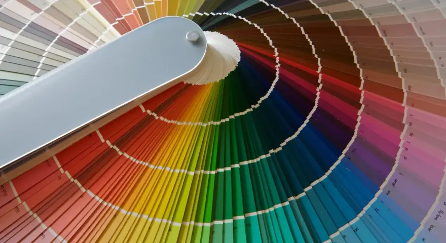 Abanico de muestras de pintura con una amplia paleta colores pastel y vibrantes, ideal para inspirar cualquier proyecto.