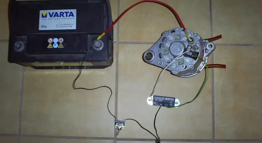 Schemat podłączenia regulatora napięcia do prądnicy C-330: akumulator, prądnica, przełącznik i żarówka.