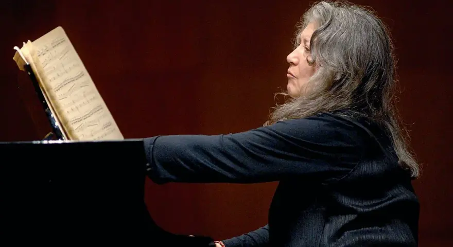 Martha Argerich, pianistka o argentyńskim pochodzeniu, gra na fortepianie, wpatrzona w nuty.