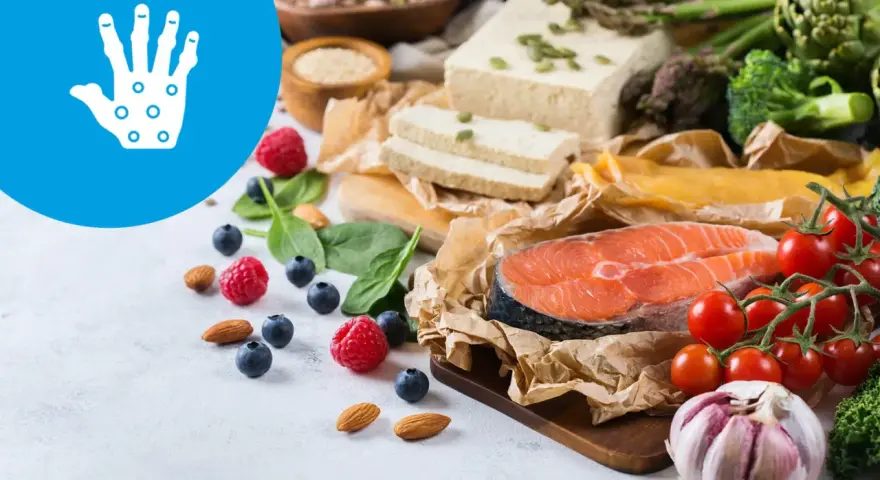 Zdrowa dieta przy łuszczycy: łosoś, warzywa, owoce, orzechy i tofu. Ikona dłoni symbolizuje ulgę.