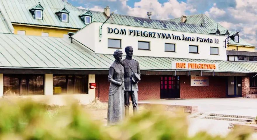 Pomnik przed Domem Pielgrzyma im. Jana Pawła II. Sprawdź ceny i godziny otwarcia baru.
