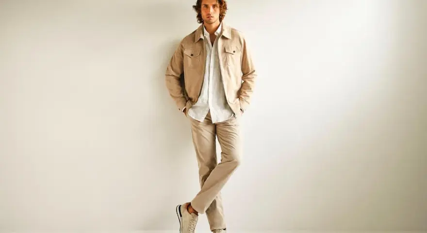 Hombre con ropa business casual en tonos beige: chaqueta, camisa y pantalones.
