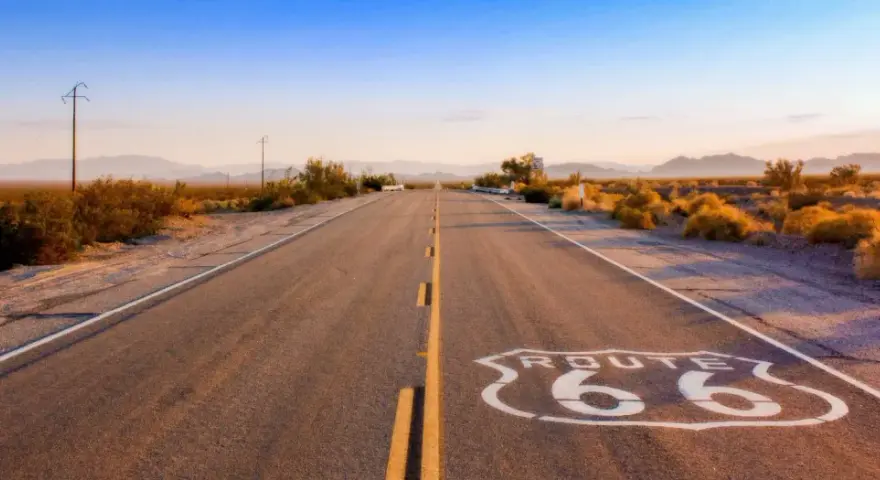 Droga Route 66 w pustynnym krajobrazie o zachodzie słońca.