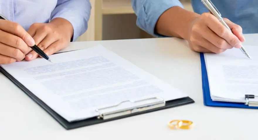 Deux mains signent des documents, symbolisant la fin d'une union. Attention au délai pour réclamer une prestation compensatoire.