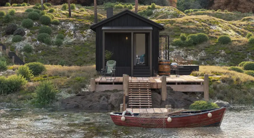 Svart stuga vid vattnet med altan och båt. Kanske behövs bygglov altan för denna idylliska plats.