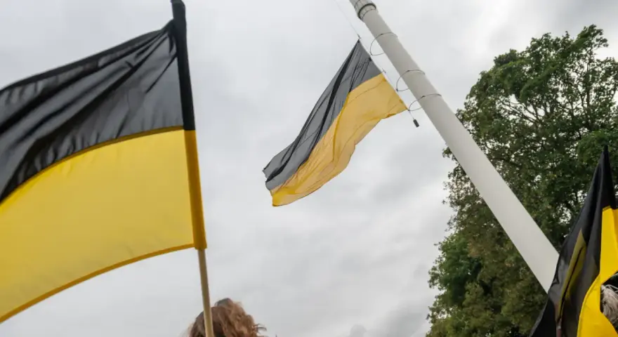Flaga Kaszub powiewa na wietrze, symbol dumy i tożsamości.