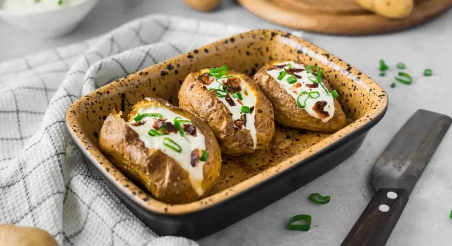 Drei gebackene Ofenkartoffeln mit Sour Cream und Speckwürfeln, ein köstliches Ofenkartoffeln Rezept.