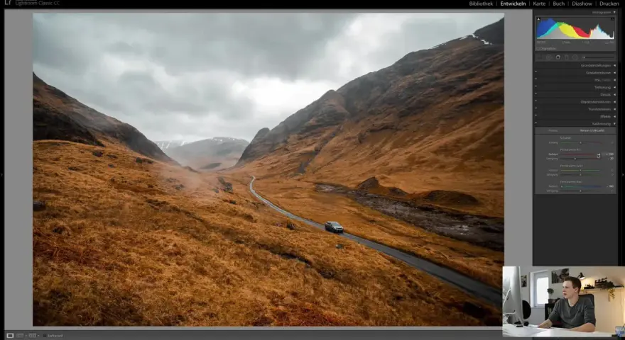 Paysage écossais traité dans Lightroom, avec une voiture sur une route sinueuse. L'ouverture sur la lumière de Lightroom France révèle des teintes chaudes et dramatiques.
