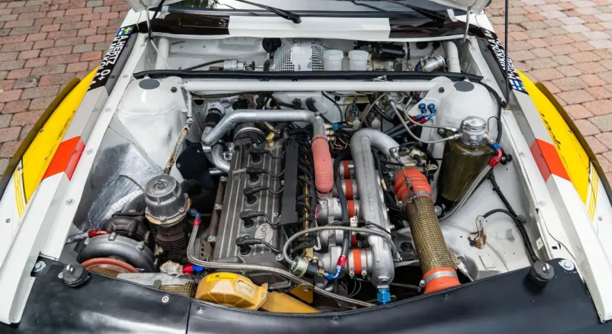 Silnik Audi quattro S1, potężna jednostka z turbosprężarką i licznymi przewodami, gotowa do rajdowych wyzwań.
