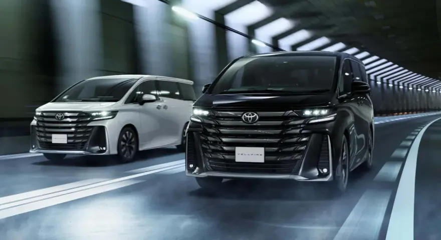 Dwa luksusowe minivany Toyota Vellfire jadące w tunelu.