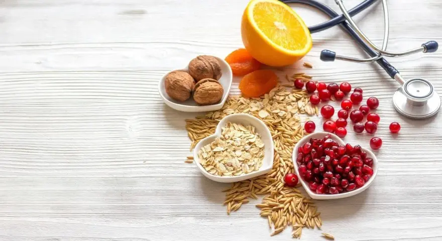 Sposób babci na obniżenie cholesterolu: orzechy, owsianka, żurawina, granat, pomarańcza i suszone morele. Stetoskop symbolizuje zdrowie.