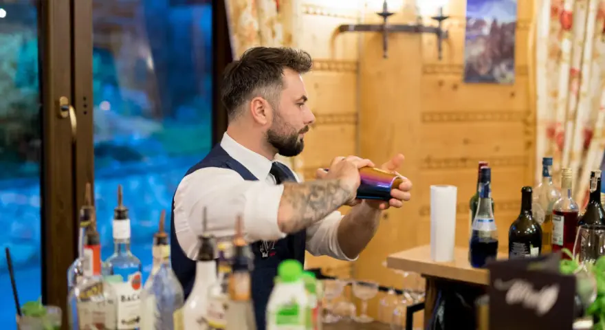Barman przygotowuje drinki na wesele. Sprawdź nasz drink bar na wesele cennik i zamów najlepsze koktajle!