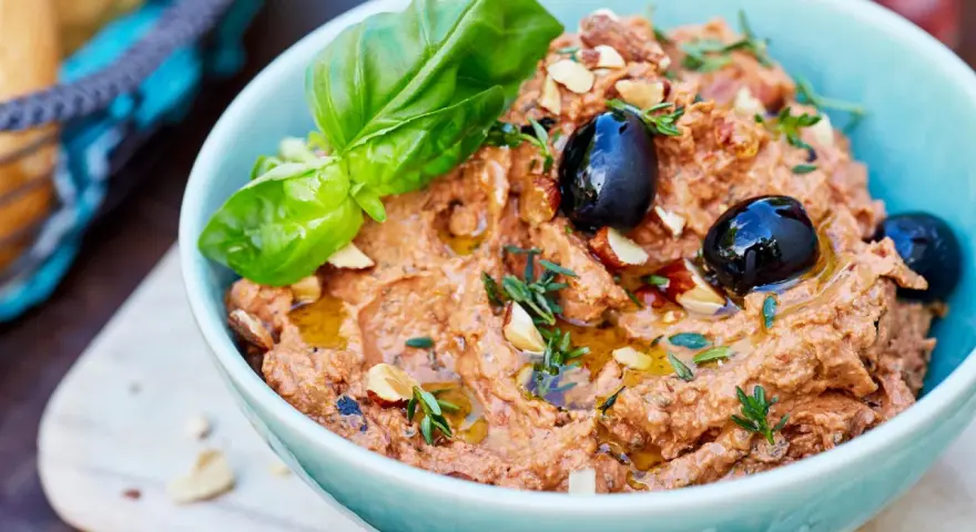 Herzhafte Dip Rezepte: Cremiger Dip mit Oliven, Mandeln und Basilikum, beträufelt mit Olivenöl. Perfekt zum Dippen!
