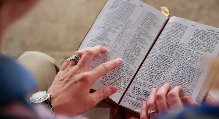 Hände halten eine Bibel. Eine Frage ist, ob Jesus Gott ist.