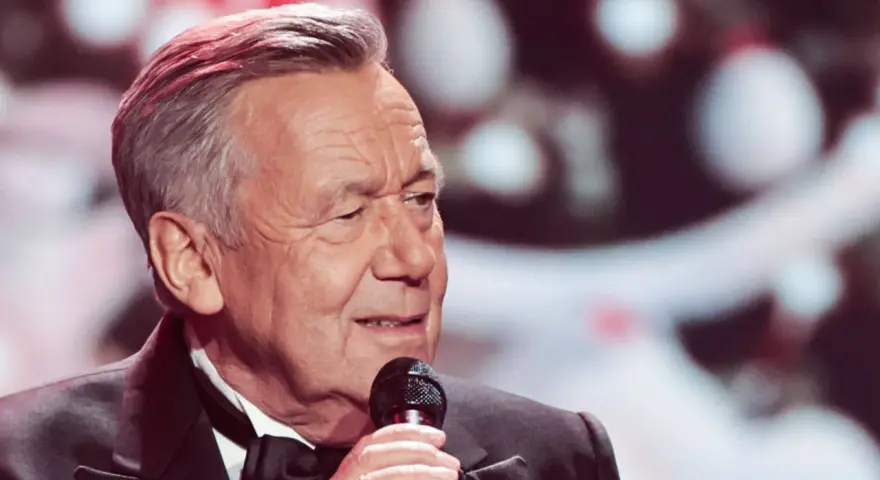 Roland Kaiser singt mit Mikrofon, im Anzug mit Fliege.