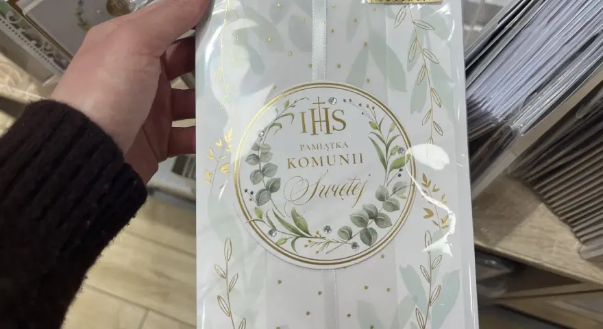 Chrzestny szuka idealnego prezentu. Elegancka pamiątka Komunii Świętej dla dziewczynki, ozdobiona złotymi gałązkami i kryształkami.