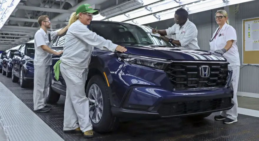 Pracownicy w fabryce Hondy z Japonii kontrolują nowy, ciemnoniebieski SUV.