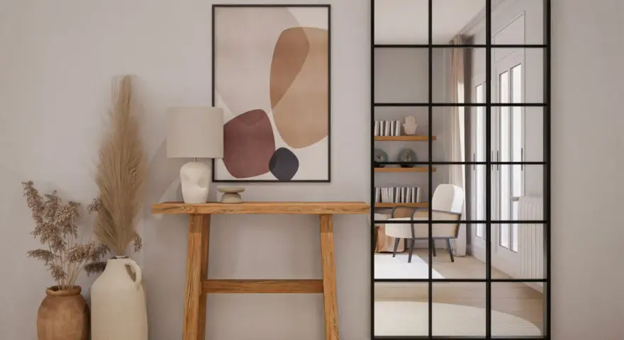 Una elegante entrada para una casa con consola de madera, lámpara, arte abstracto y espejo industrial.