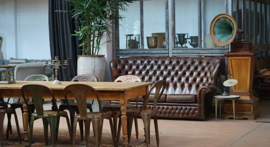 Stary gramofon i pikowana kanapa w salonie. Jak odnowić stare meble, by nadać im nowy charakter?