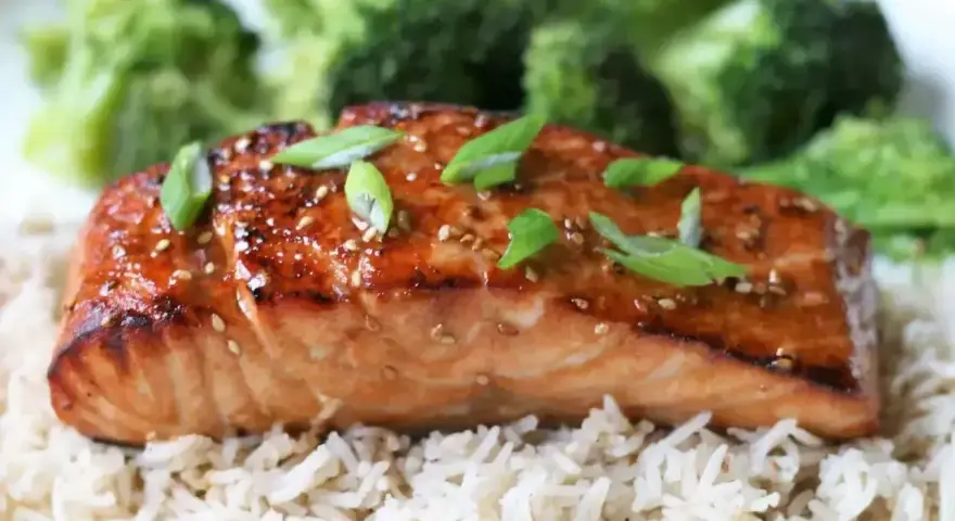 Łosoś w sosie teriyaki na ryżu z brokułami, posypany sezamem i szczypiorkiem. Pyszne danie.