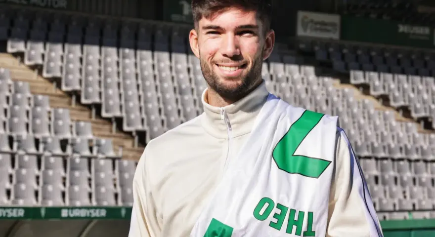 Théo Zidane sonríe con una bufanda del equipo en el estadio.