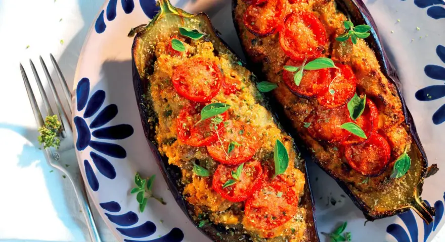 Melanzane ripiene pugliesi, gustose e profumate, con pomodoro e basilico fresco, pronte per essere gustate.