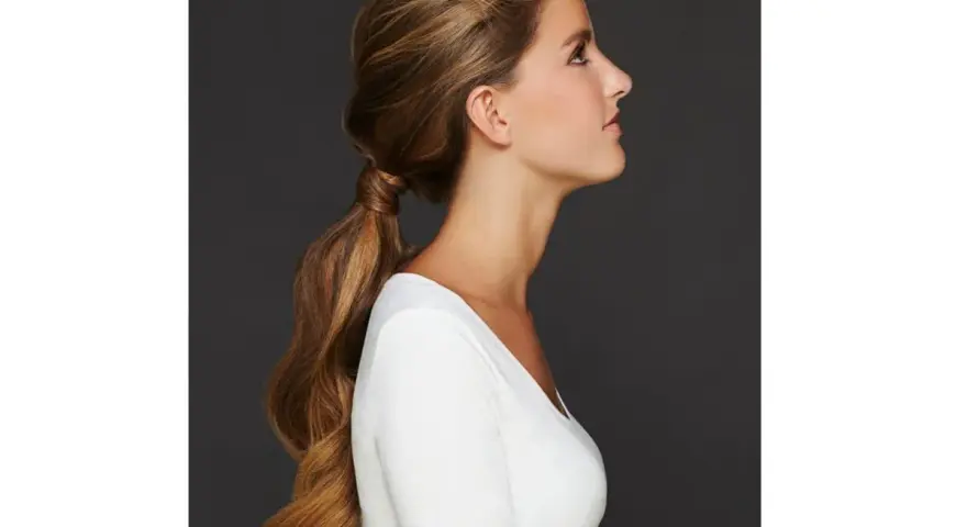 Capelli lunghi e mossi raccolti in una coda bassa, un'idea per semplici acconciature matrimonio invitata.