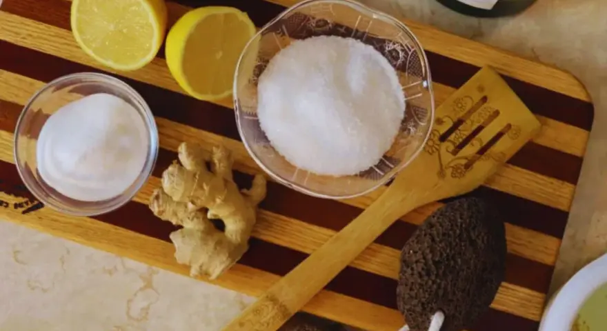 Ingredients for a homemade foot soak to remove dead skin: lemons, ginger, sugar, and a pumice stone.